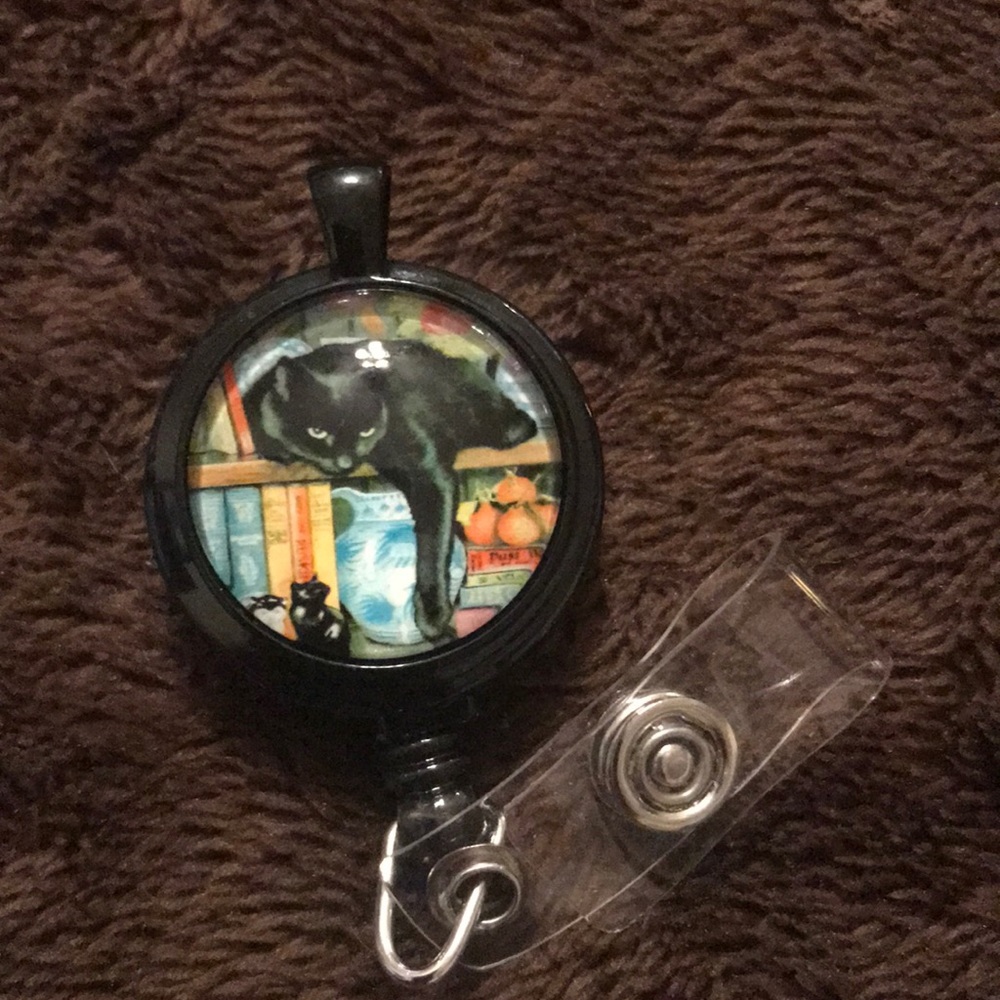 Black cat on book shelf necklace or badge reel